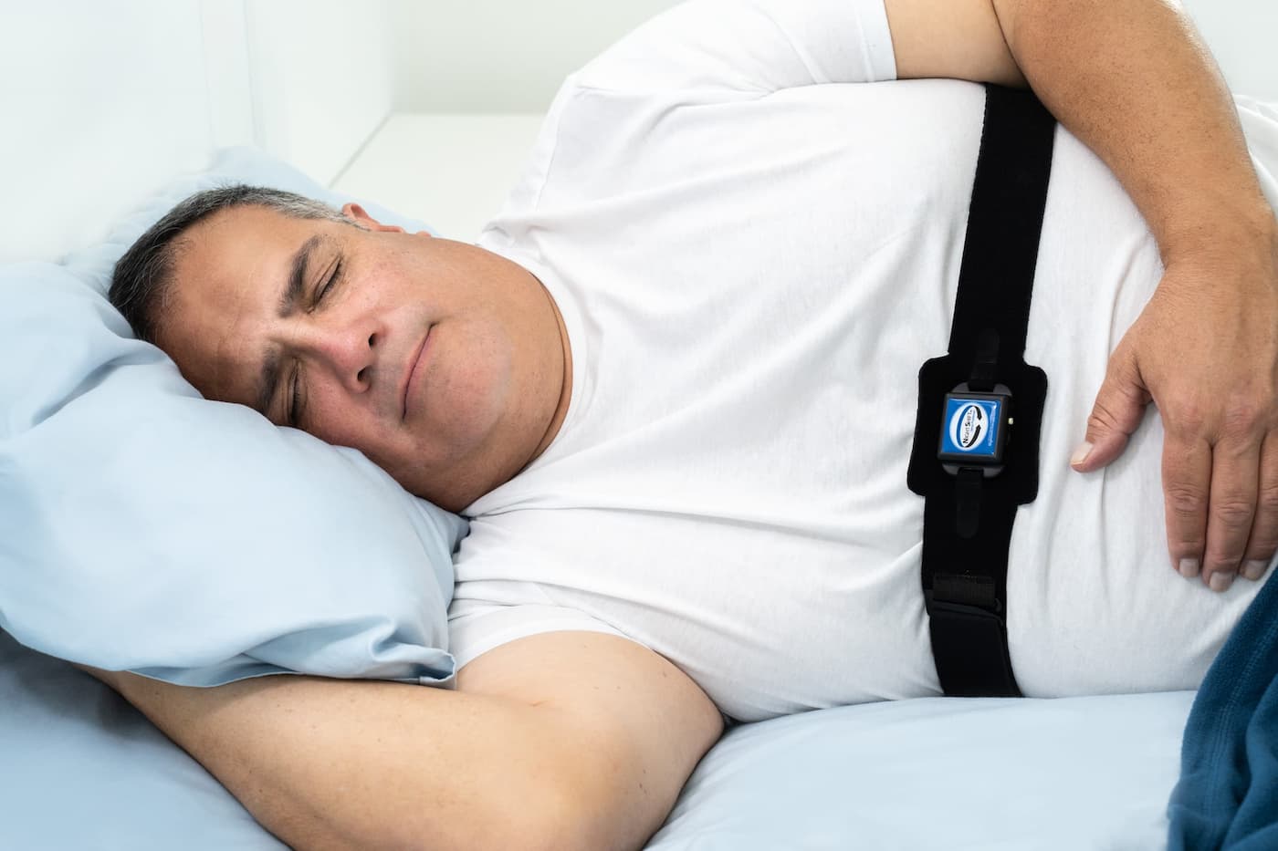 Hombre durmiendo con el cinturón abdominal Night Shift